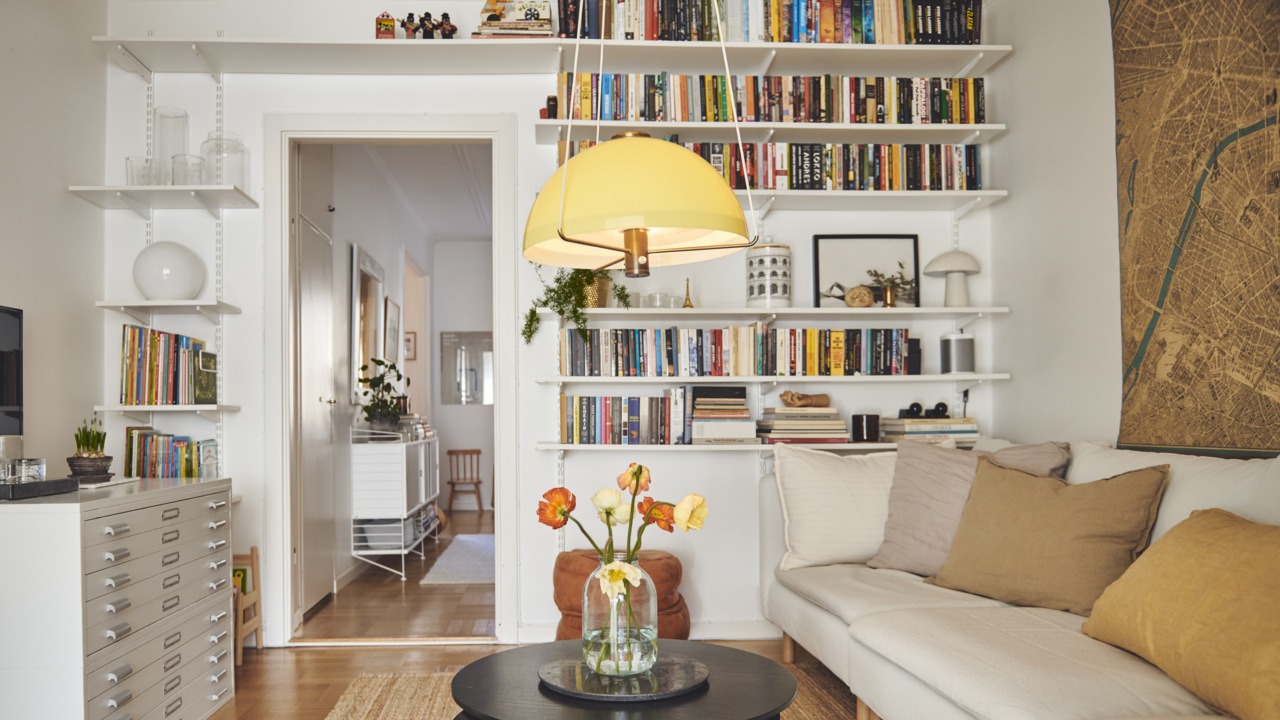 Sala con sofá, mesa de centro, cómoda y librería Sparring de Elfa que rodea la puerta.