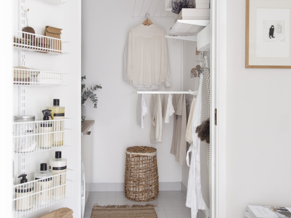 Pesula, jossa on Classic by Elfan valkoinen säilytyskaluste ja kuivaushyllyt, joissa on pyykkiä ja ovisäilytys siivoustuotteita varten.