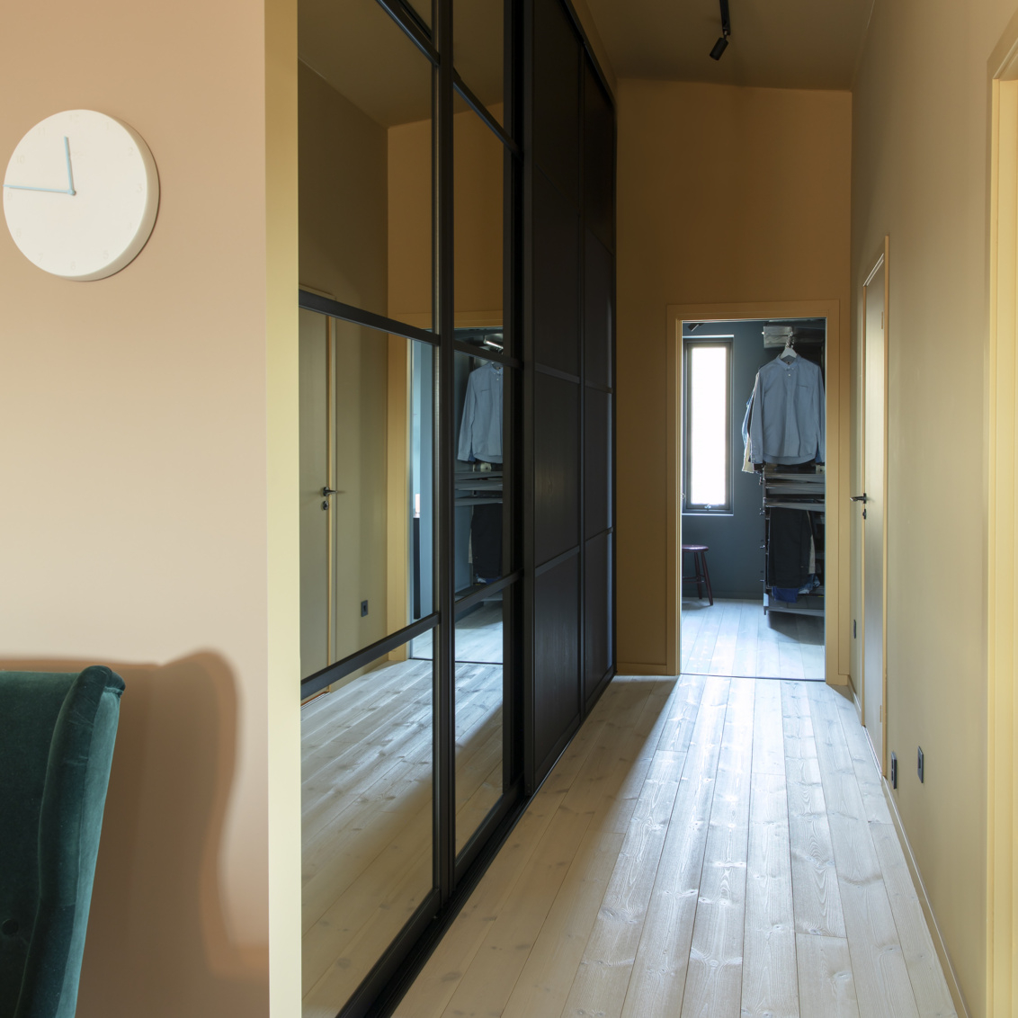 Käytävä, jossa on Elfan vaatekaappi, mustat liukuovet ja peili.