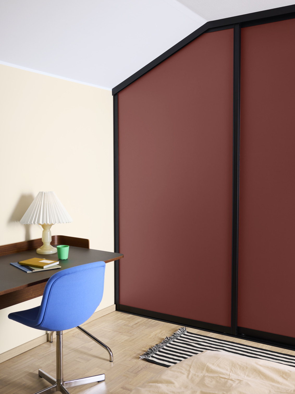 Sovrum med garderob som har vinröda skjutdörrar från Elfa, under snedtak.