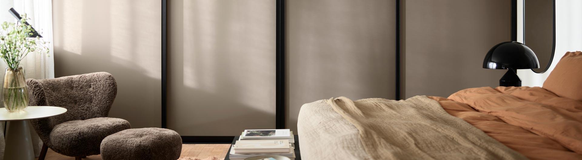 Soverom med garderobe fra Elfa med skyvedørene Artic i lysebrun.