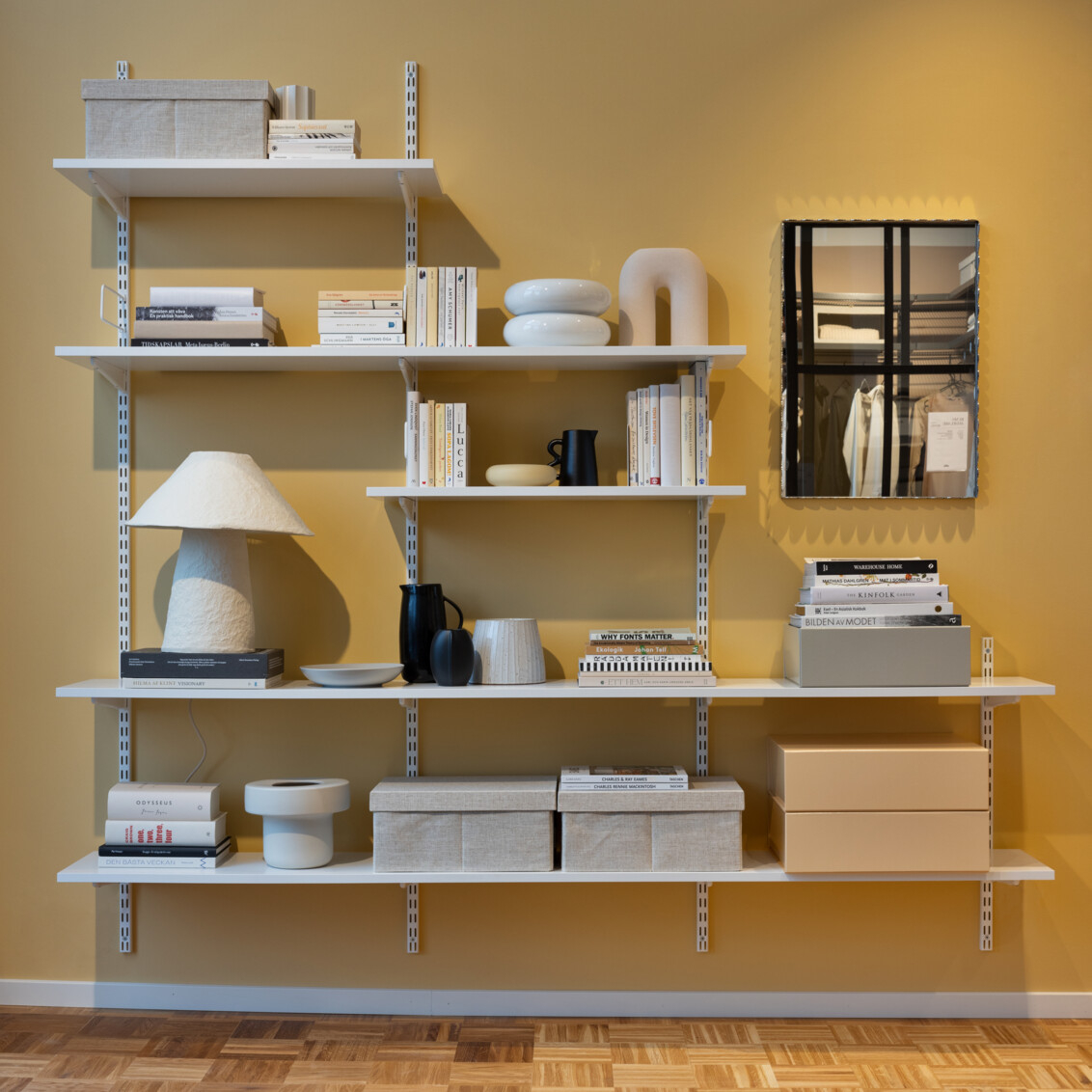 Förvaring i tv rum för tygboxar på hylla samt böcker. 