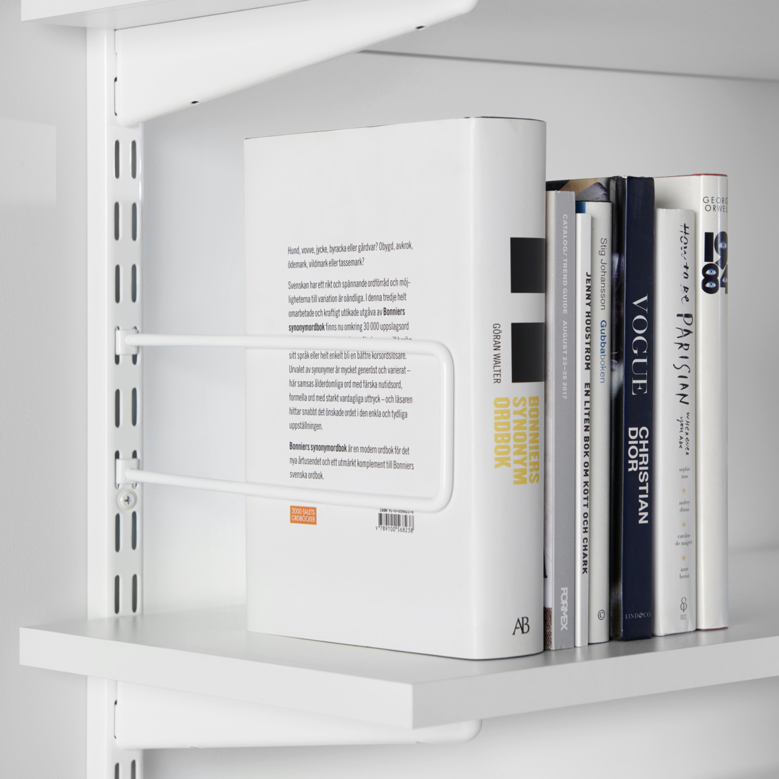 Libros sujetos en su lugar con un extremo de libro Sparring para riel de pared de Elfa.