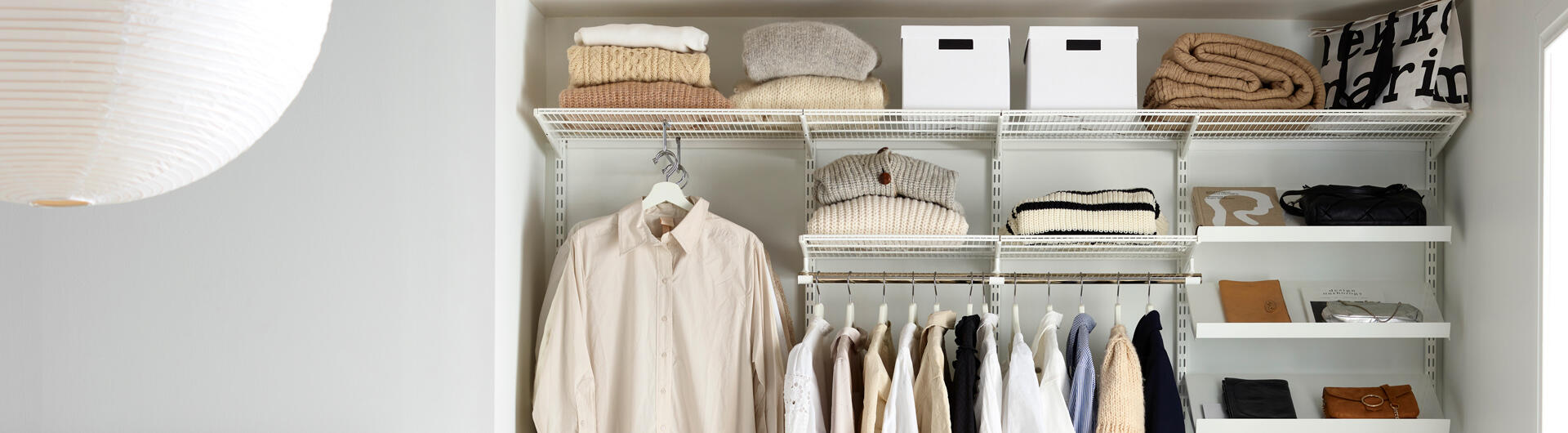 Avoin vaatekaappiratkaisu makuuhuoneessa hyllyillä ja vaatetangolla.