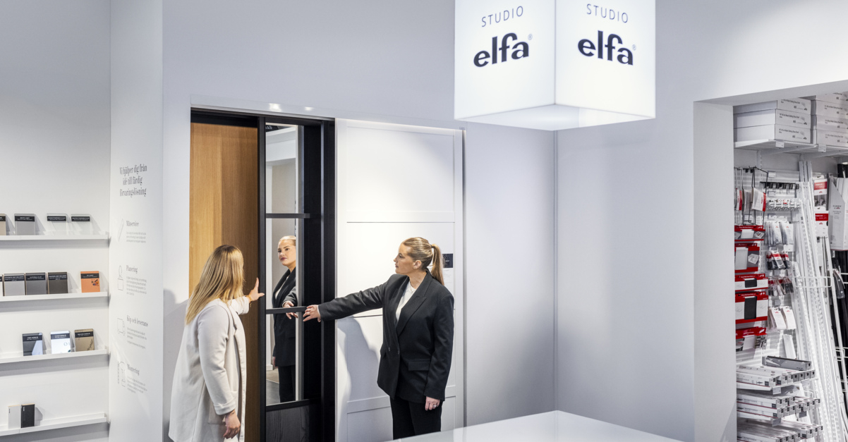 En kvinna tittar på skjutdörrar i Studio Elfa tillsammans med en planeringsexpert.