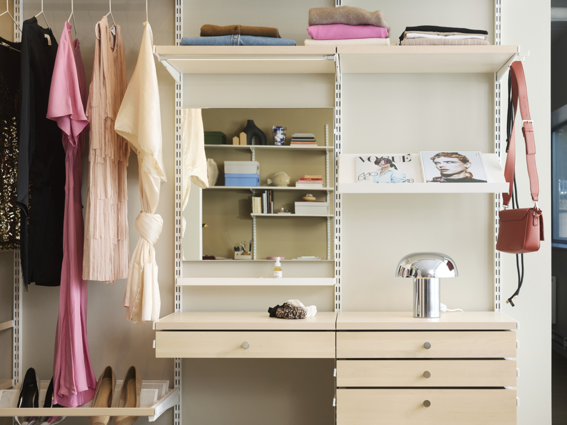 Inredning med förvaring på hyllor, klädstång och urdragbara backar med lådfront  i vitt och björk.