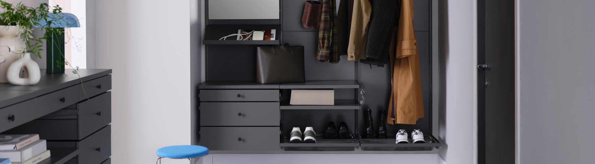 Pasillo con armario Décor+ de Elfa en gris con cajones extraíbles, espejo y estantes para zapatos.