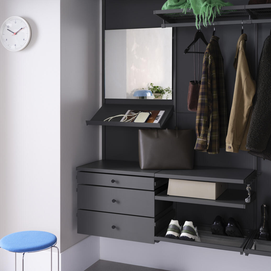 Eteinen, jossa on Elfan harmaa Décor+ vaatekaappi ja ripustettuja vaatteita, ulosvedettävät laatikot, peili ja kenkähyllyt.