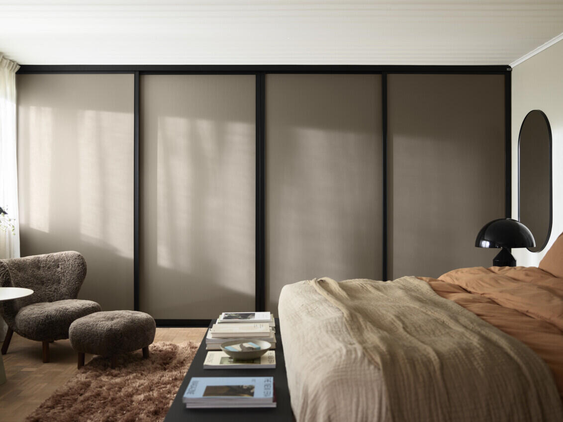 Soverom med garderobe fra Elfa med skyvedørene Artic i lysebrun.