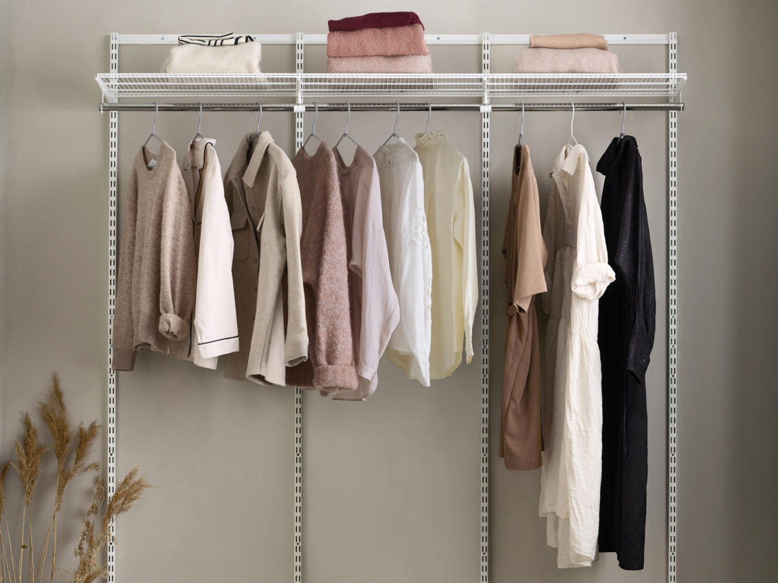 Hängande kläder i ett startpaket från Classic by Elfa som är vitt med tre sektioner. 
