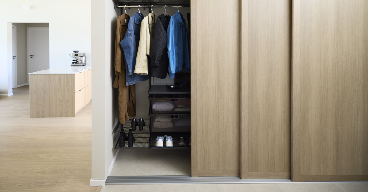 Hall med Elfa garderob som har skjutdörrarna Grace med fyllningen ljus ek.