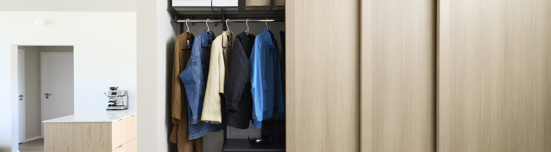 Hall med Elfa garderob som har skjutdörrarna Grace med fyllningen ljus ek.