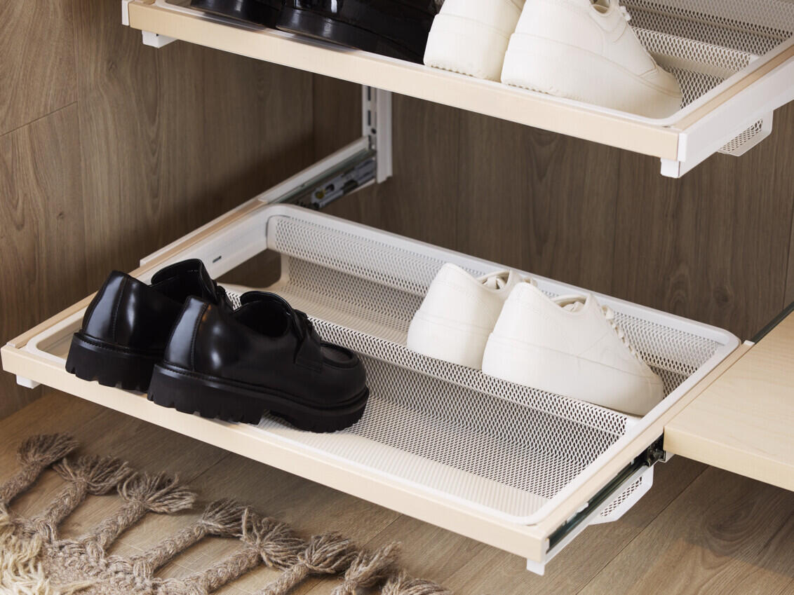 Décor+ by Elfa pull-out shoe shelf in white with white and black shoes.
