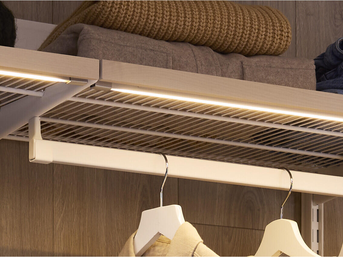 Iluminación LED Décor+ fijada a la parte inferior de una repisa de malla metálica de Elfa.